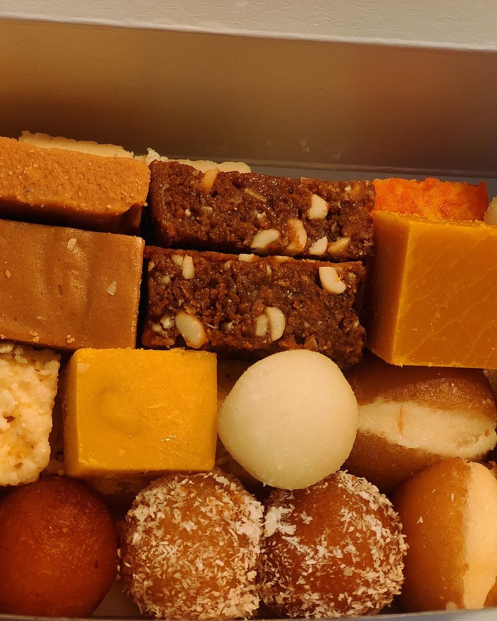 An assorted box of Indian sweets from Baba Sweets — barfi, gulab jamun, milk cake and more
